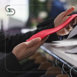 store employee holding red tie closeup 1